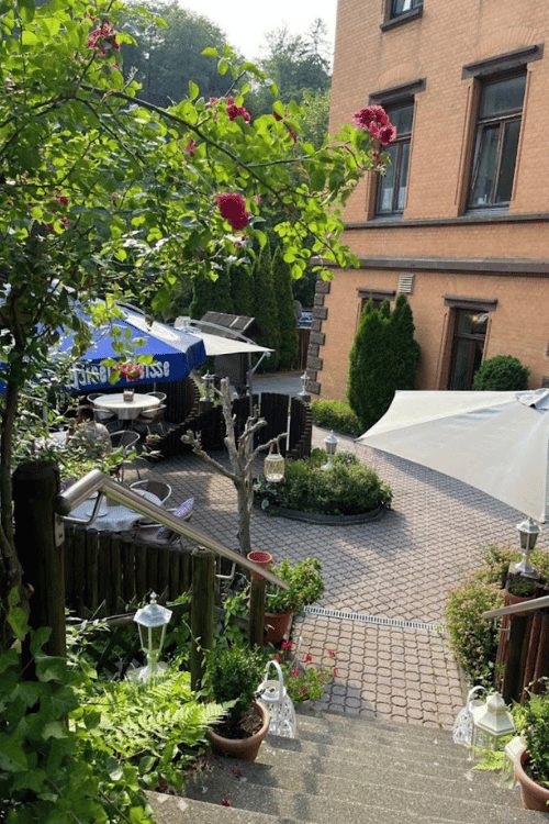 Gartenterrasse mit Rosen und Sonnenschirmen