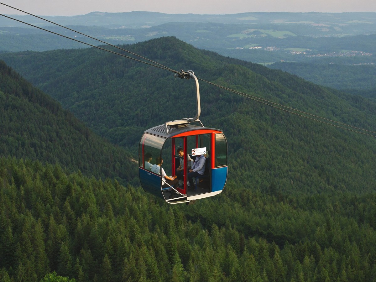 Seilbahngondel über bewaldeten Bergen