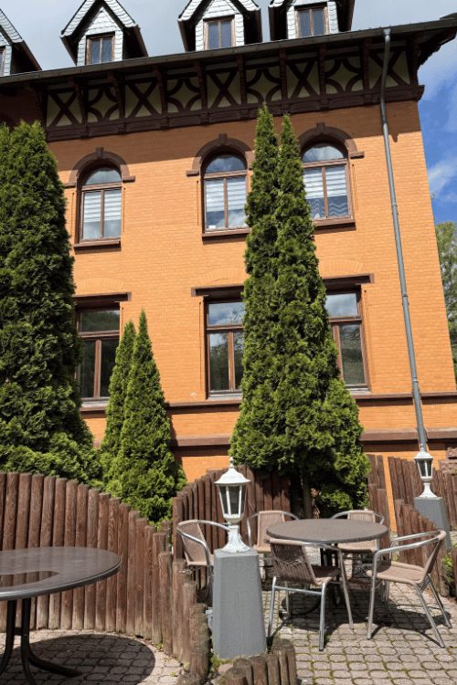 Terrasse mit Tischen vor dem Backsteingebäude