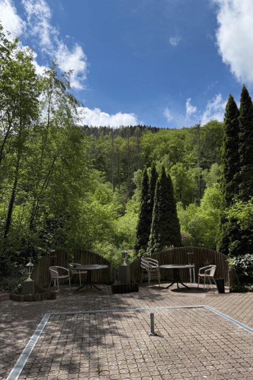 Terrassentische mit Blick auf den bewaldeten Hang